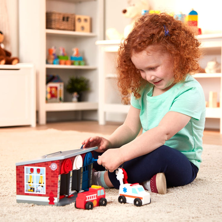 A kid playing with the Melissa & Doug Toy Keys and Cars Wooden Rescue Vehicles and Garage (7 pcs)