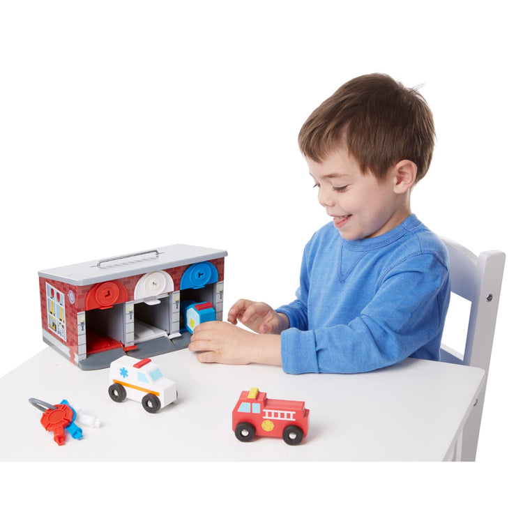 A child on white background with the Melissa & Doug Toy Keys and Cars Wooden Rescue Vehicles and Garage (7 pcs)