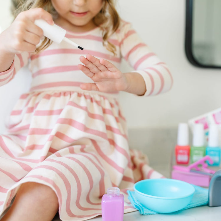 A kid playing with the Melissa & Doug Love Your Look Pretend Nail Care Play Set – 22 Pieces for Mess-Free Play Mani-Pedis (DOES NOT CONTAIN REAL COSMETICS)