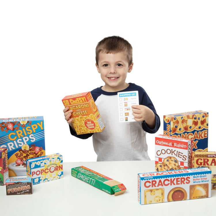 A child on white background with the Melissa & Doug Grocery Boxes for Pretend Kitchens and Shopping (11 pcs)