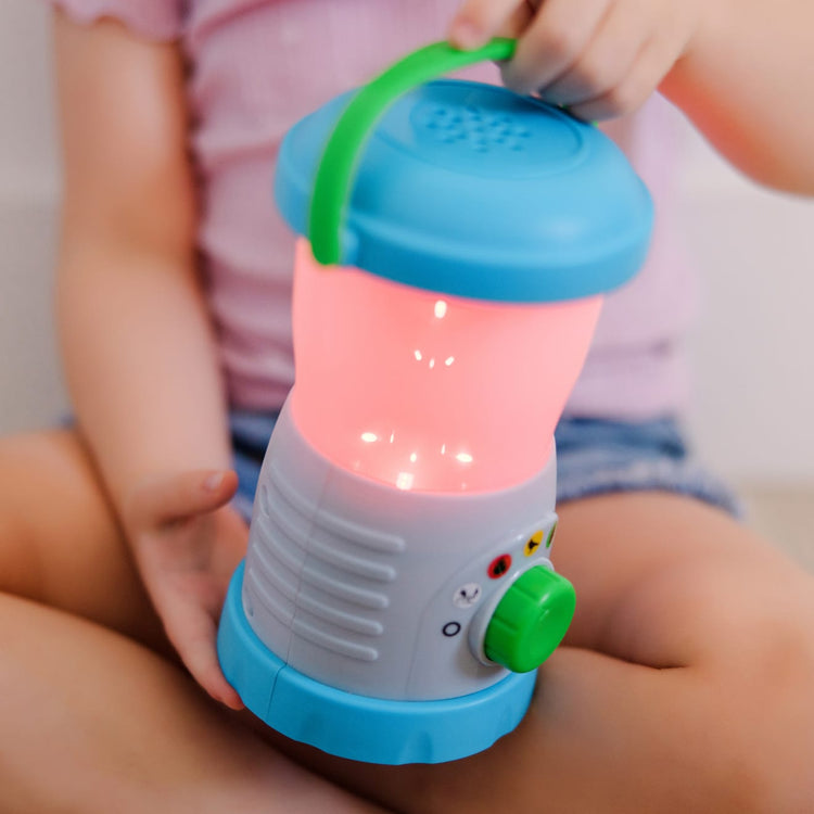 A kid playing with the Melissa & Doug Let’s Explore™ Light & Sound Camping Lantern Play Set