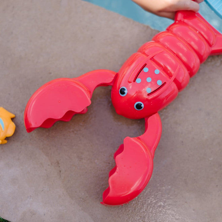 A kid playing with the Melissa & Doug Sunny Patch Louie Lobster Claw Catcher - Grab-and-Squeeze Pool Toy