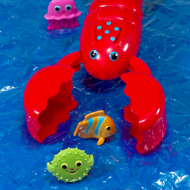 The loose pieces of the Melissa & Doug Sunny Patch Louie Lobster Claw Catcher - Grab-and-Squeeze Pool Toy