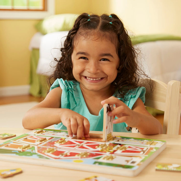 A kid playing with the Melissa & Doug Hide and Seek Farm Wooden Activity Board With Barnyard Animal Magnets