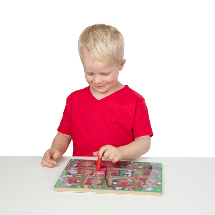 A child on white background with the Melissa & Doug Magnetic Wand Number Maze - Wooden Puzzle Activity