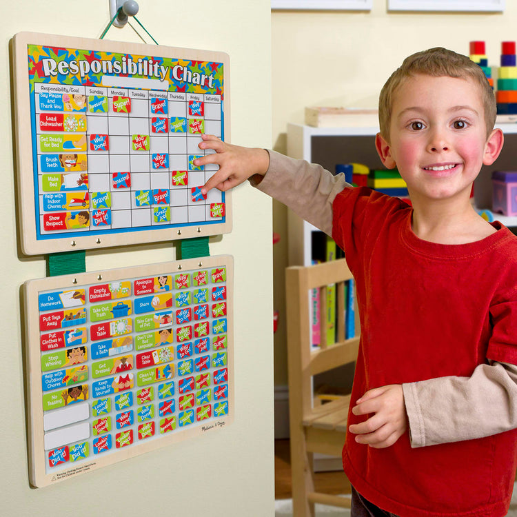 A kid playing with the Melissa & Doug Magnetic Responsibility Chart