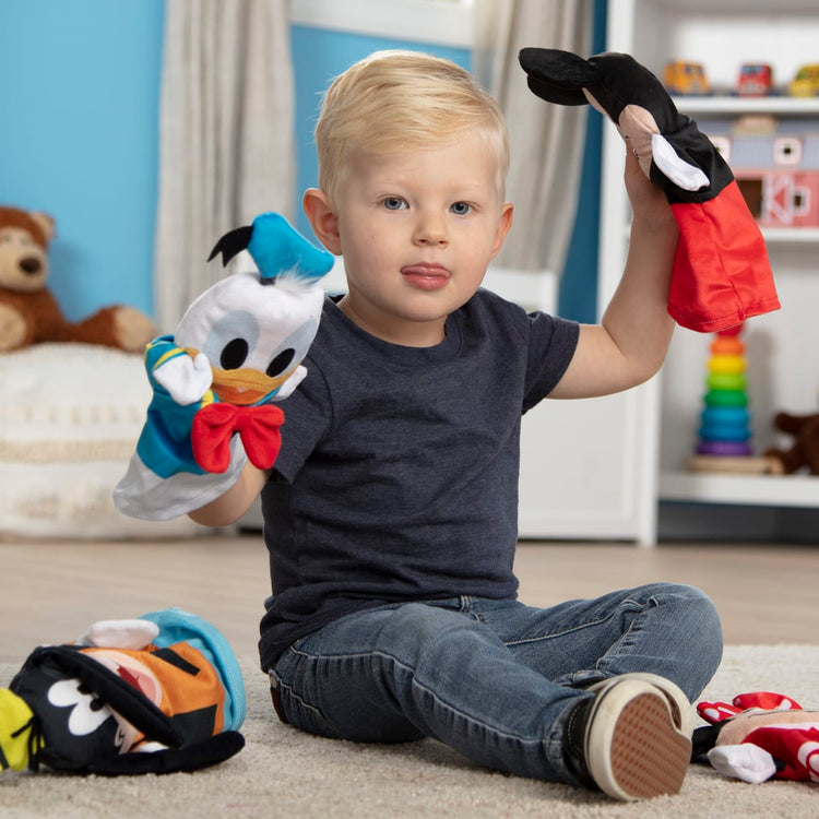 A kid playing with the Mickey Mouse & Friends Soft & Cuddly Hand Puppets