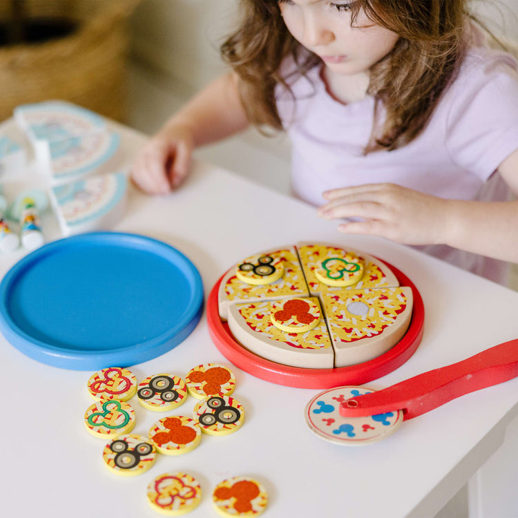 A kid playing with the Melissa & Doug Mickey Mouse Wooden Pizza and Birthday Cake Set (32 pcs) - Play Food