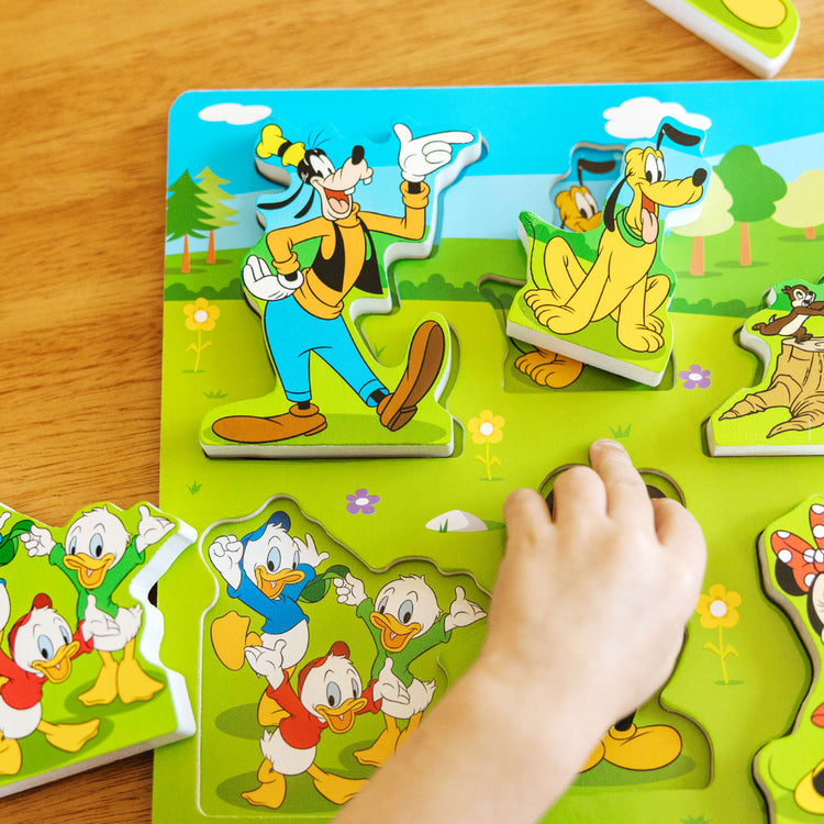 A kid playing with the Melissa & Doug Disney Mickey Mouse Clubhouse Wooden Chunky Puzzle (8 pcs)