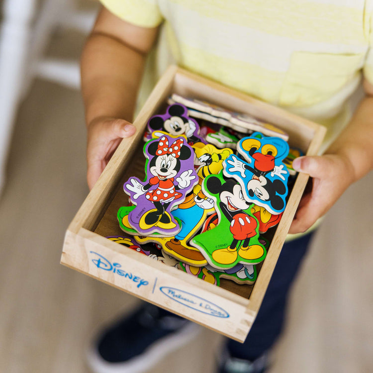 A kid playing with the Melissa & Doug Disney Mickey Mouse Clubhouse Wooden Character Magnets (20 pcs)