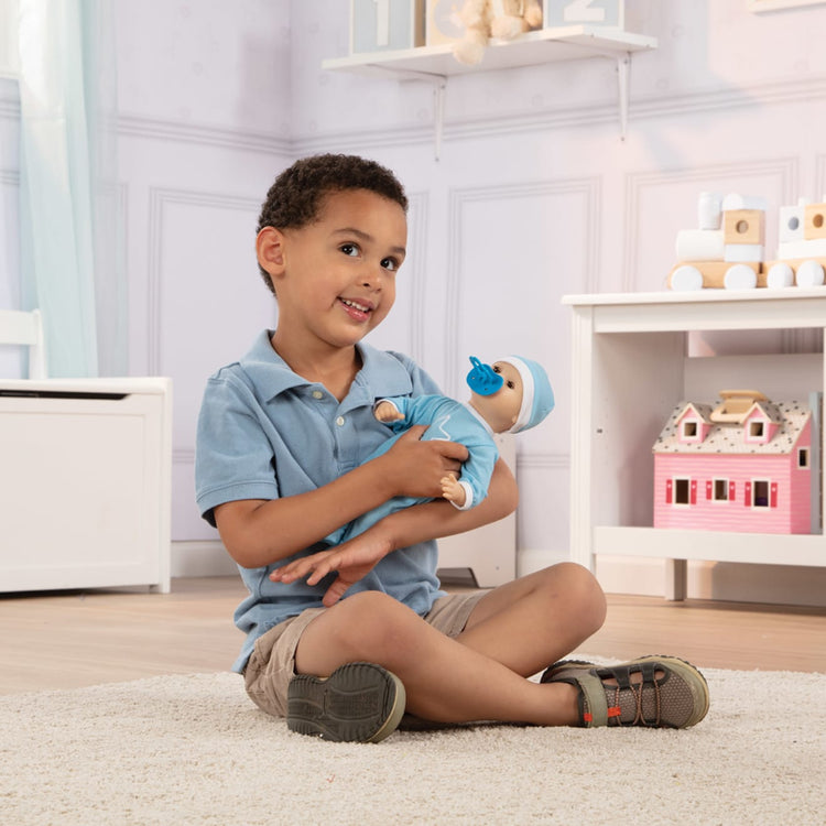 A kid playing with the Melissa & Doug Mine to Love Jordan 12” Light Skin-Tone Boy Baby Doll with Romper, Cap, Pacifier