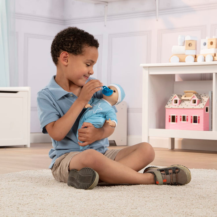 A kid playing with the Melissa & Doug Mine to Love Jordan 12” Light Skin-Tone Boy Baby Doll with Romper, Cap, Pacifier