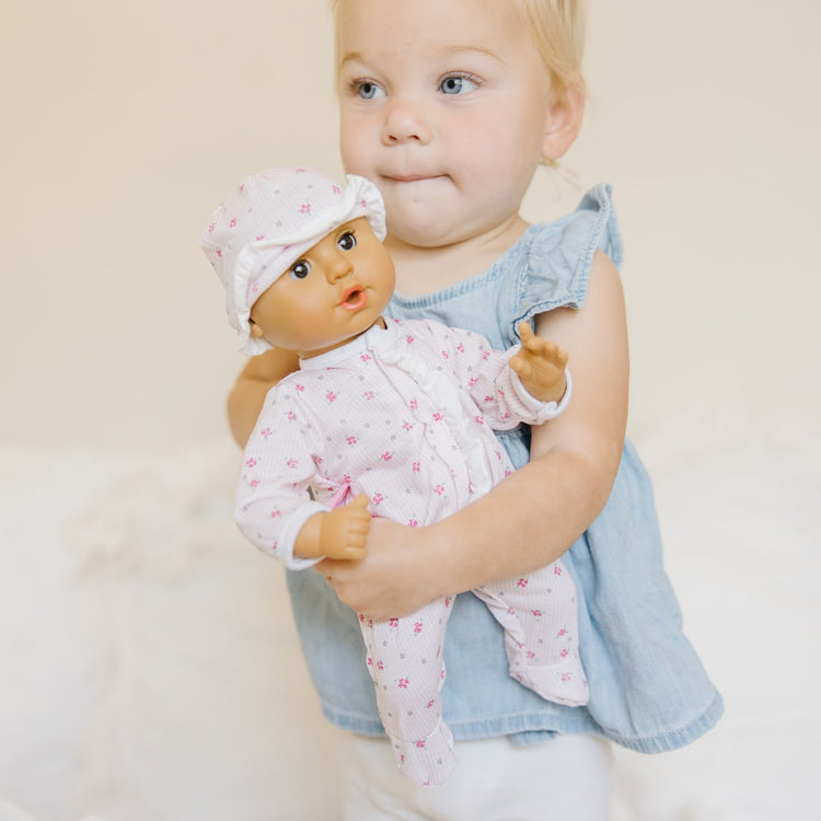 A kid playing with the Melissa & Doug Mine to Love Mariana 12" Poseable Baby Doll With Romper, Hat