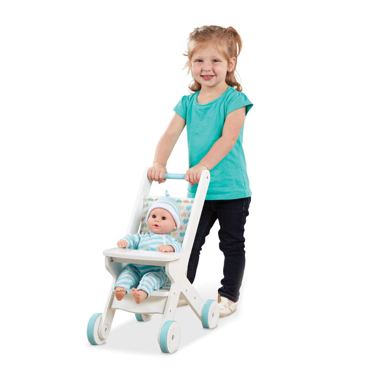 A child on white background with the Melissa & Doug Mine to Love Wooden Play Stroller for Dolls, Stuffed Animals - White (18”H x 8”W x 11”D Assembled)