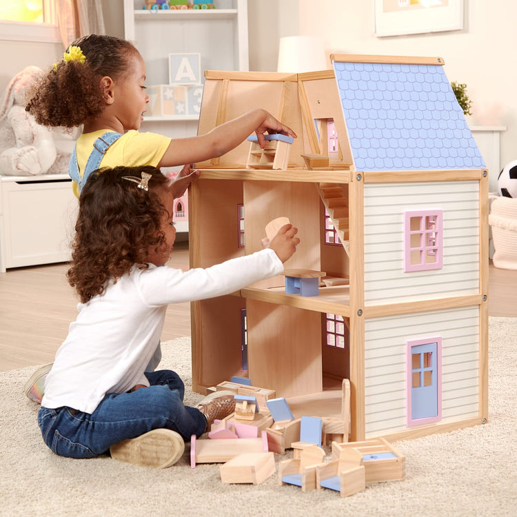 A kid playing with the Melissa & Doug Modern Wooden Multi-Level Dollhouse With 19 pcs Furniture [White]