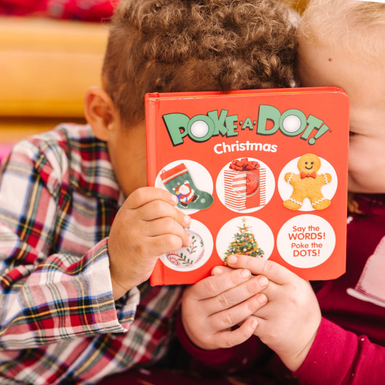 A kid playing with the Melissa & Doug Children’s Book – Poke-a-Dot: Christmas (Board Book with Buttons to Pop)