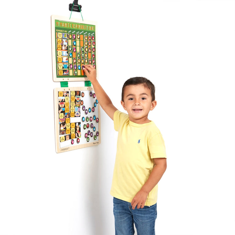 A child on white background with the Melissa & Doug Deluxe Wooden Magnetic Responsibility Chart With 90 Magnets