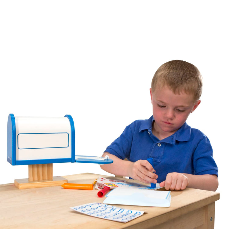 A child on white background with the Melissa & Doug My Own Wooden Mailbox Activity Set and Educational Toy