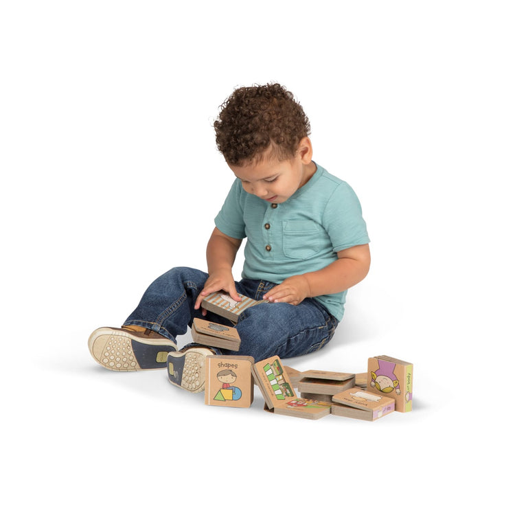 A child on white background with the Melissa & Doug Children's Book - Natural Play Book Tower: Little Learning Books