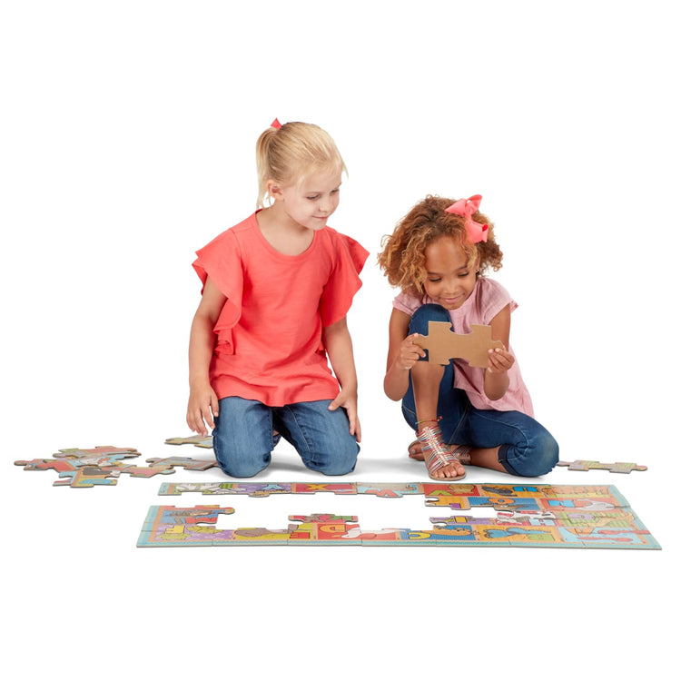 A child on white background with the Melissa & Doug Natural Play Giant Floor Puzzle: ABC Animals (35 Pieces)