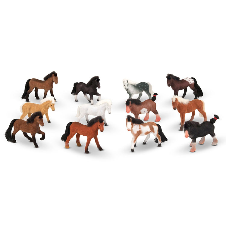 The loose pieces of the Melissa & Doug Pasture Pals - 12 Collectible Horses With Wooden Barn-Shaped Crate