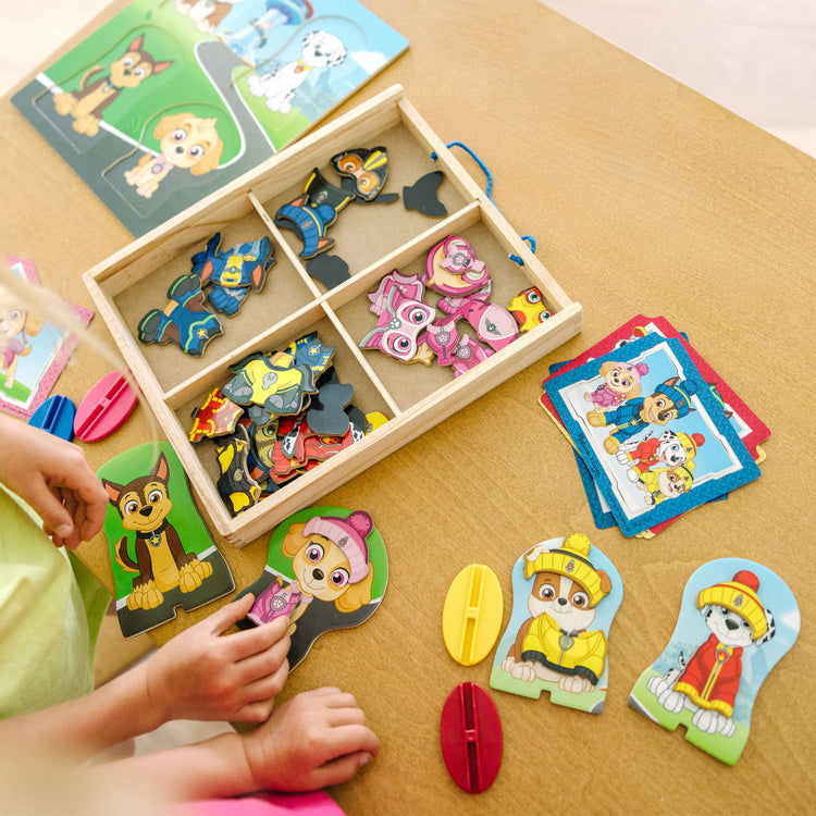 A kid playing with the Melissa & Doug PAW Patrol Wooden Magnetic Pretend Play (64 Pieces)