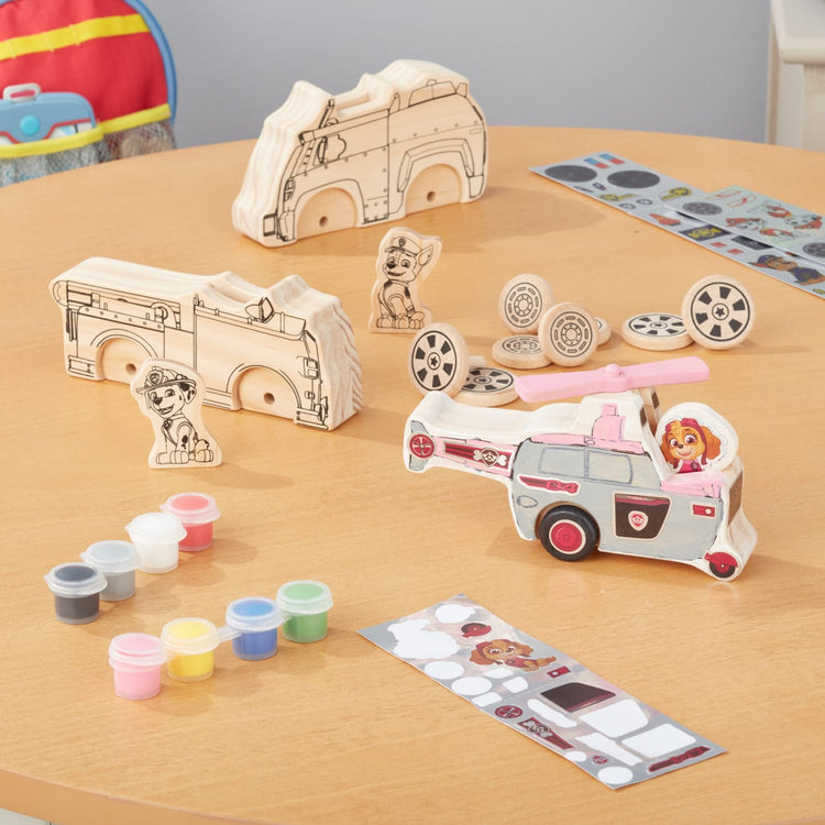 The front of the box for the Melissa & Doug PAW Patrol Wooden Vehicles Craft Kit - 3 Decorate Your Own Vehicles, 3 Play Figures