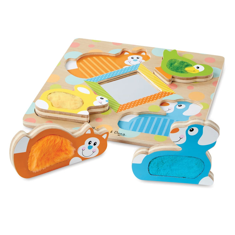 A child on white background with the Melissa & Doug First Play Wooden Touch and Feel Puzzle Peek-a-Boo Pets With Mirror