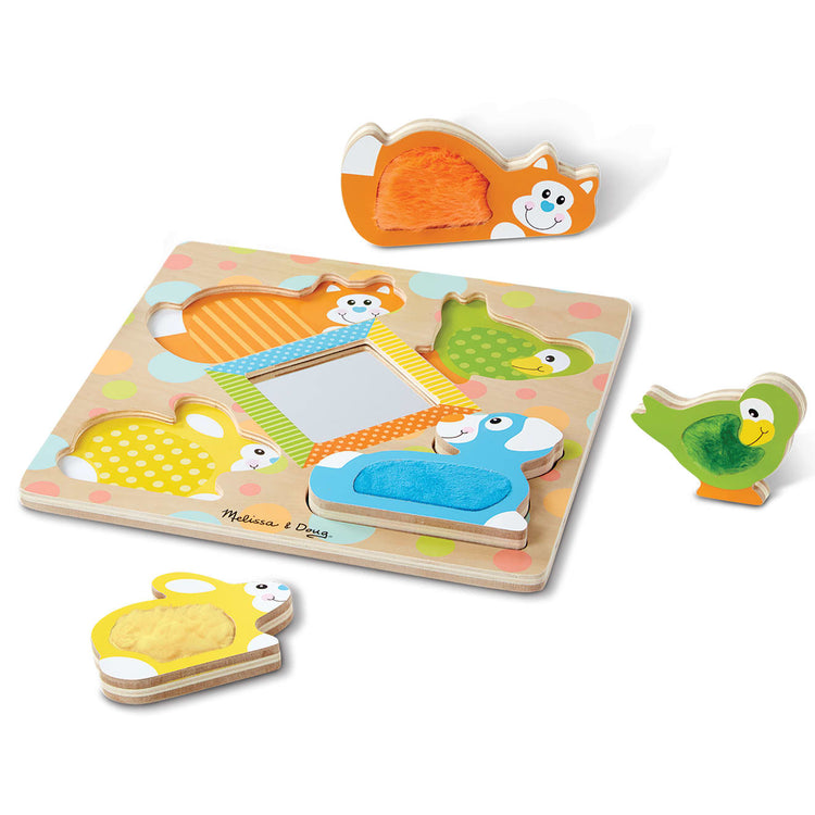 The loose pieces of the Melissa & Doug First Play Wooden Touch and Feel Puzzle Peek-a-Boo Pets With Mirror