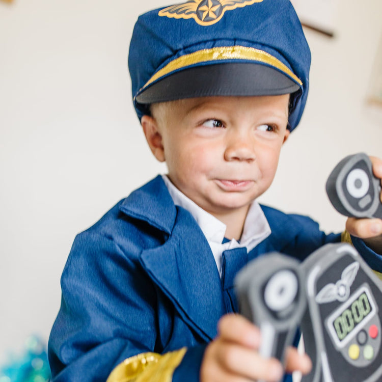 A kid playing with the Melissa & Doug Pilot Costume Role Play Set (6 pcs) - Jacket, Tie, Hat, Wings, Steering Yoke, Checklist