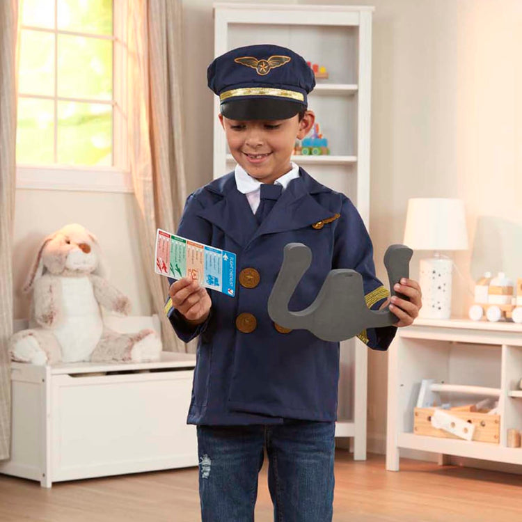 A kid playing with the Melissa & Doug Pilot Costume Role Play Set (6 pcs) - Jacket, Tie, Hat, Wings, Steering Yoke, Checklist