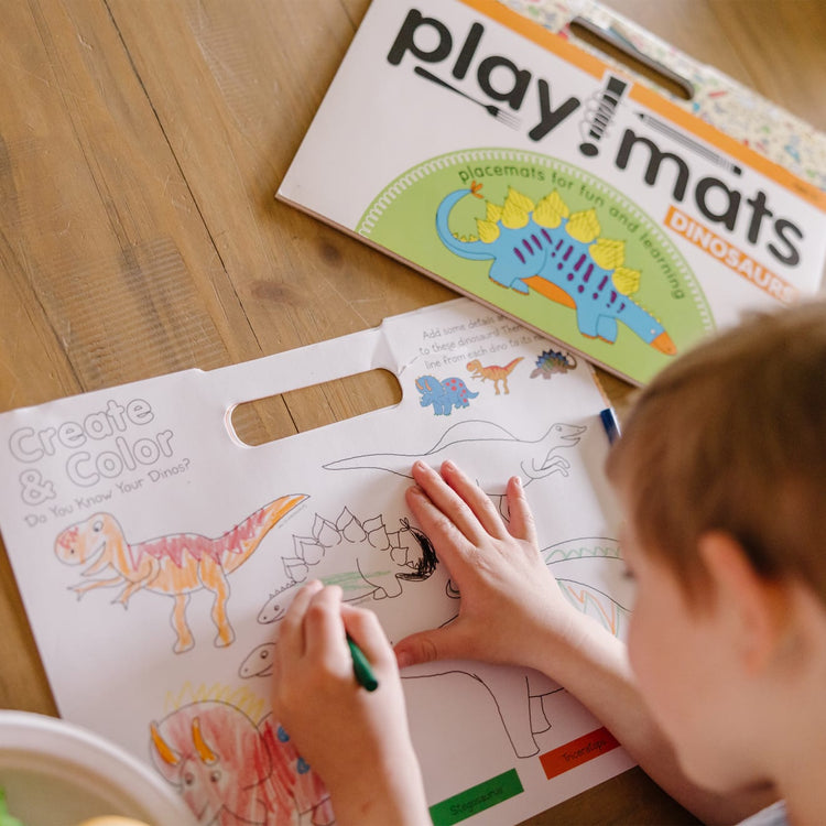 The front of the box for the Melissa & Doug Playmats Dinosaurs Take-Along Paper Coloring And Learning Activity Pads (24 Pages)