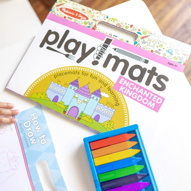 The front of the box for the Melissa & Doug Playmats Enchanted Kingdom Take-Along Paper Coloring And Learning Activity Pads (24 Pages)
