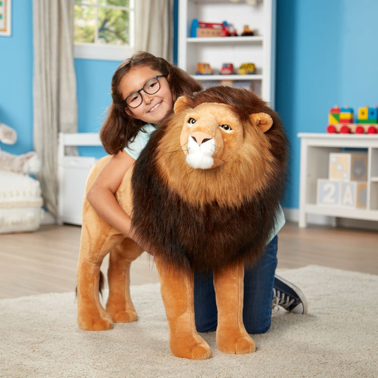 A kid playing with the Melissa & Doug Standing Lion Lifelike Stuffed Animal With Full Mane, More Than 2 Feet Tall, Nearly Three Feet Long