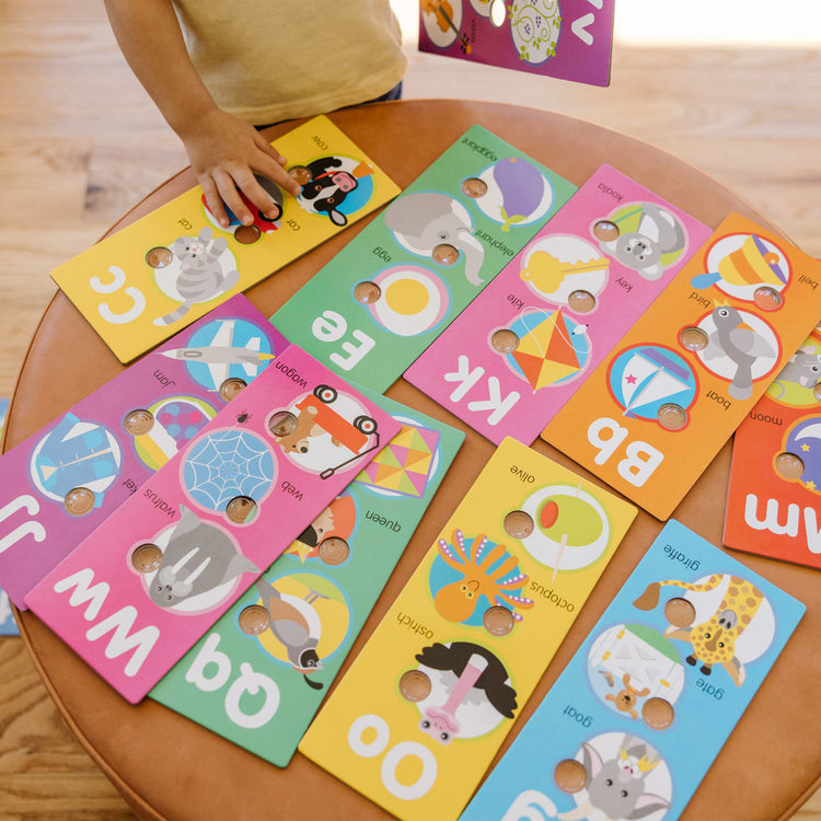 A kid playing with the Melissa & Doug Poke-A-Dot Jumbo Alphabet Learning Cards - 13 Double-Sided Letter and First Words Cards with Buttons to Pop