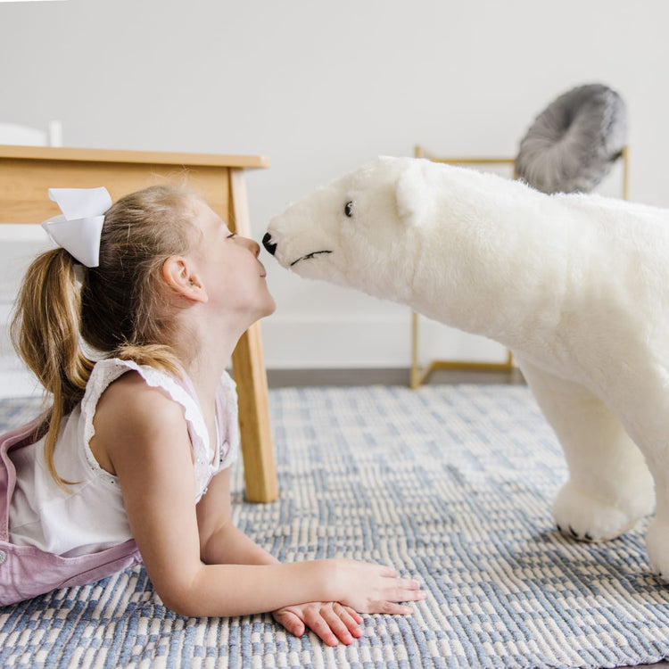 A kid playing with the Melissa & Doug Giant Polar Bear - Lifelike Stuffed Animal (nearly 3 feet long)