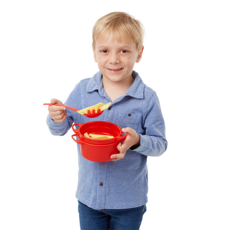 A child on white background with the Melissa & Doug Prepare & Serve Pasta Play Food Set - 55 Pieces