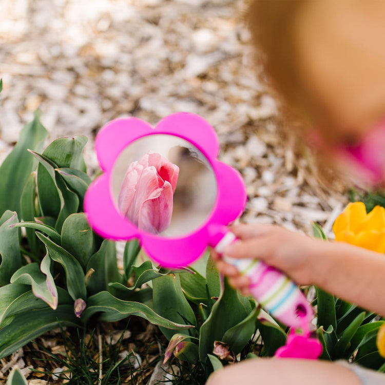 A kid playing with the Melissa & Doug Sunny Patch Pretty Petals Flower Magnifying Glass With Shatterproof Lens