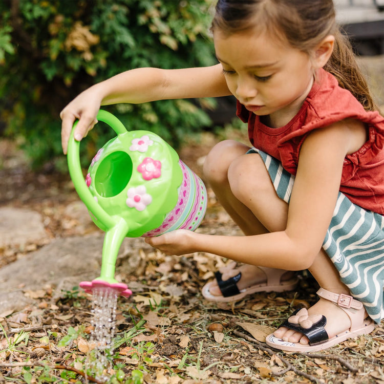 A kid playing with the Melissa & Doug Sunny Patch Pretty Petals Flower Watering Can - Pretend Play Toy