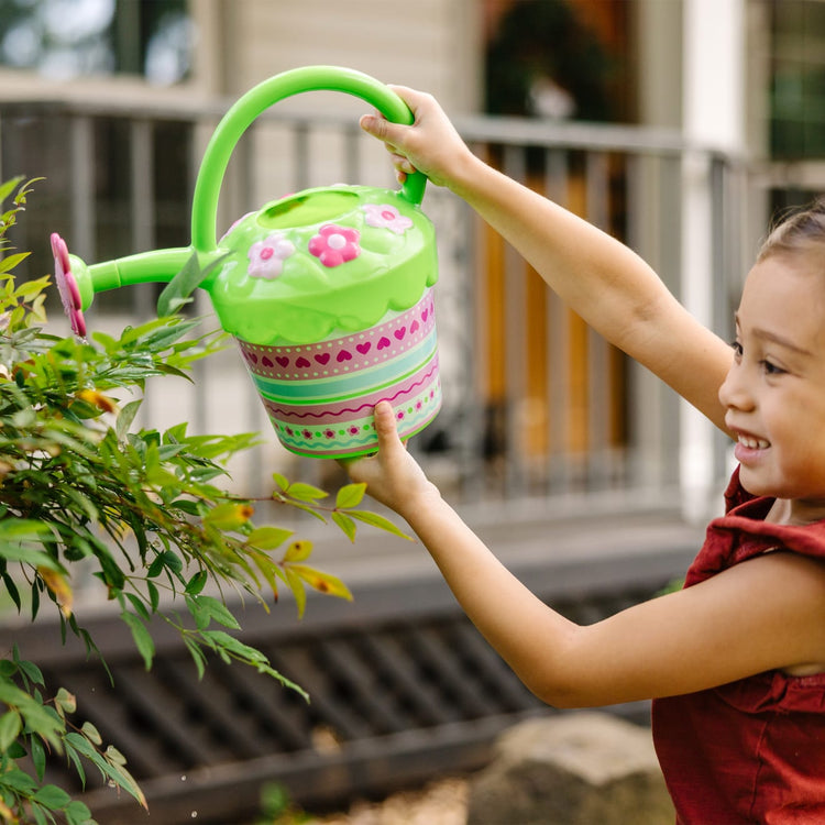 A kid playing with the Melissa & Doug Sunny Patch Pretty Petals Flower Watering Can - Pretend Play Toy