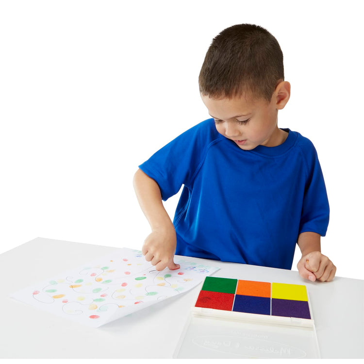 A child on white background with the Melissa & Doug Rainbow Stamp Pad - 6 Washable Inks