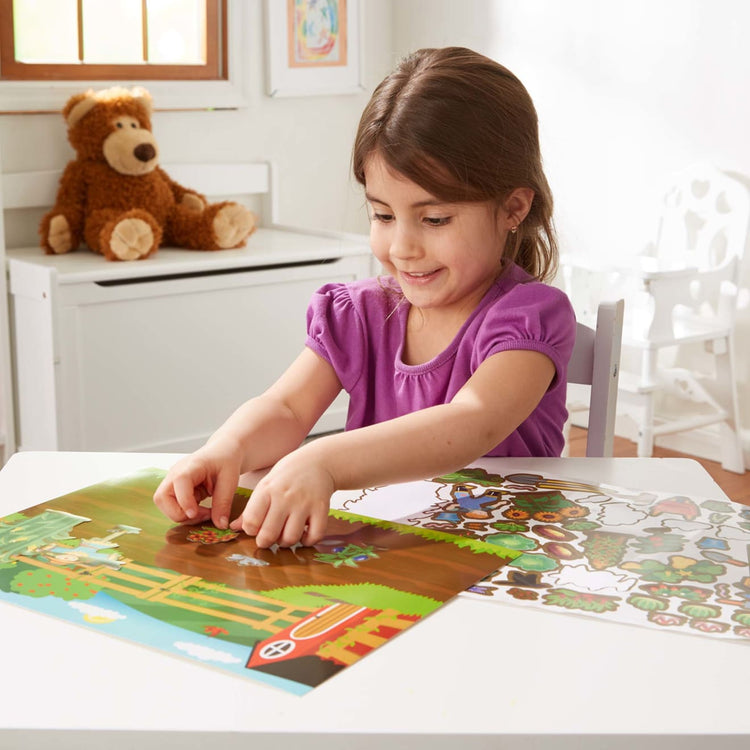 A kid playing with the Reusable Sticker Pad Bundle - Jungle, Farm & Under the Sea (Amazon Only)