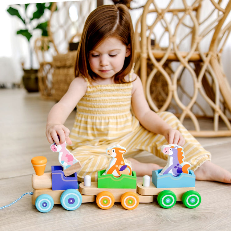 A kid playing with the Melissa & Doug First Play Wooden Rocking Farm Animals Pull Train