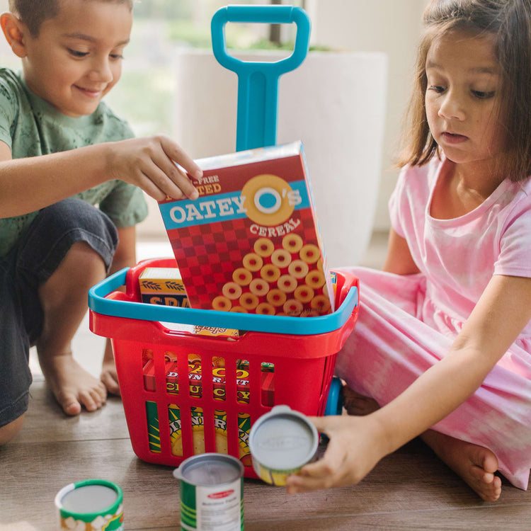 A kid playing with the Melissa & Doug Fill and Roll Grocery Basket Play Set With Play Food Boxes and Cans (11 pcs)