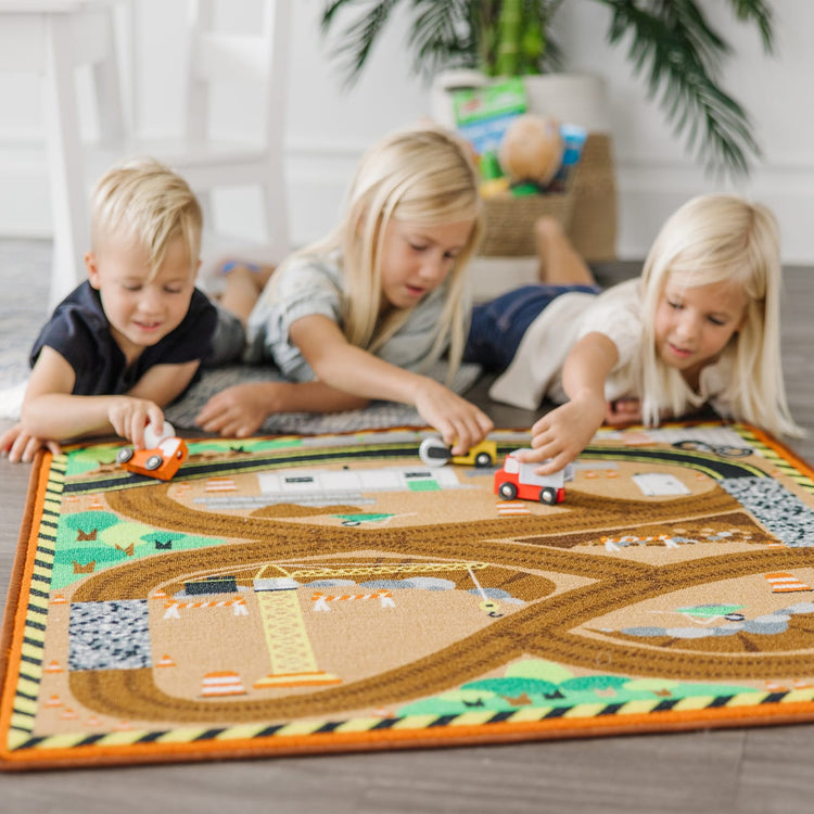 A kid playing with the Melissa & Doug Round the Construction Zone Work Site Rug With 3 Wooden Trucks (39 x 36 inches)