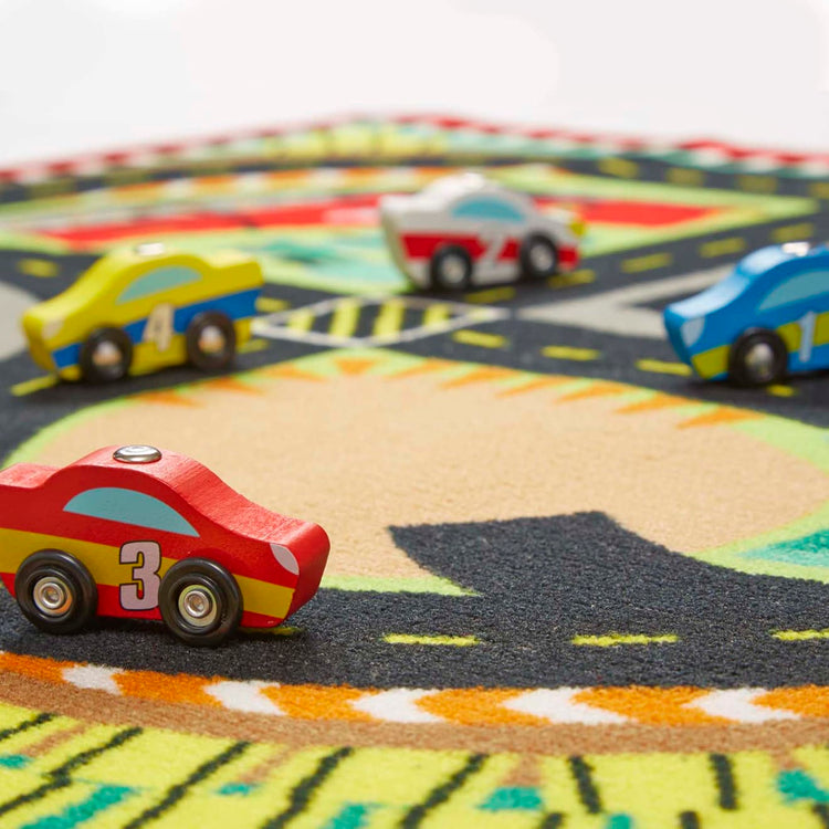 the Melissa & Doug Round the Speedway Race Track Rug With 4 Race Cars (39 x 36 inches)