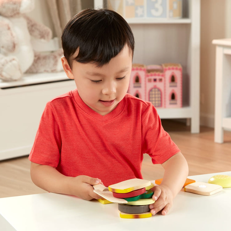 A kid playing with the Melissa & Doug Wooden Sandwich-Making Pretend Play Food Set