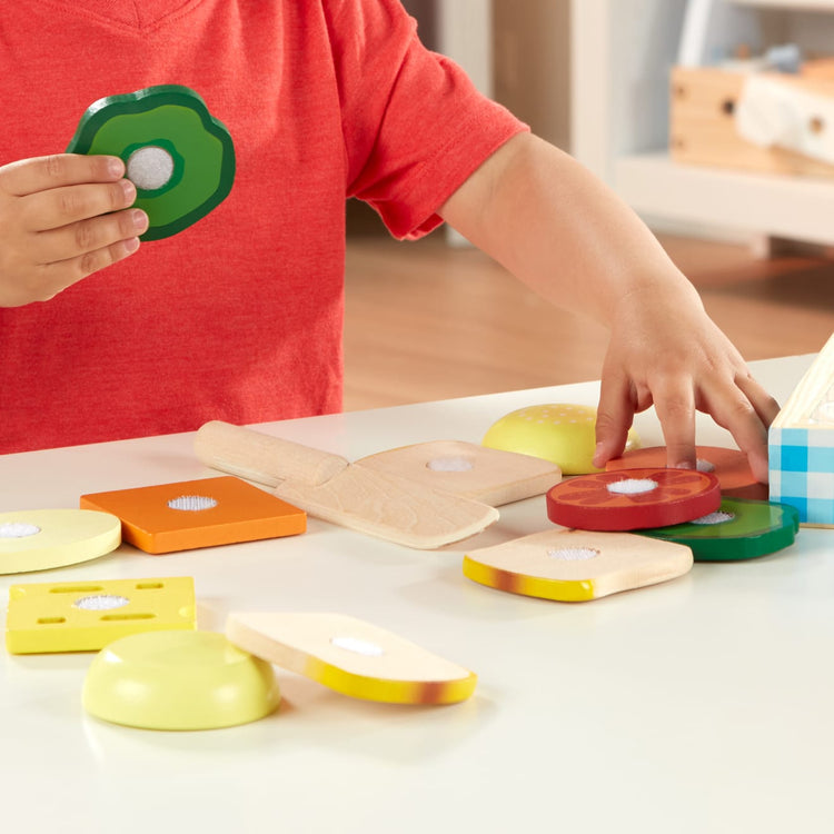 A kid playing with the Melissa & Doug Wooden Sandwich-Making Pretend Play Food Set