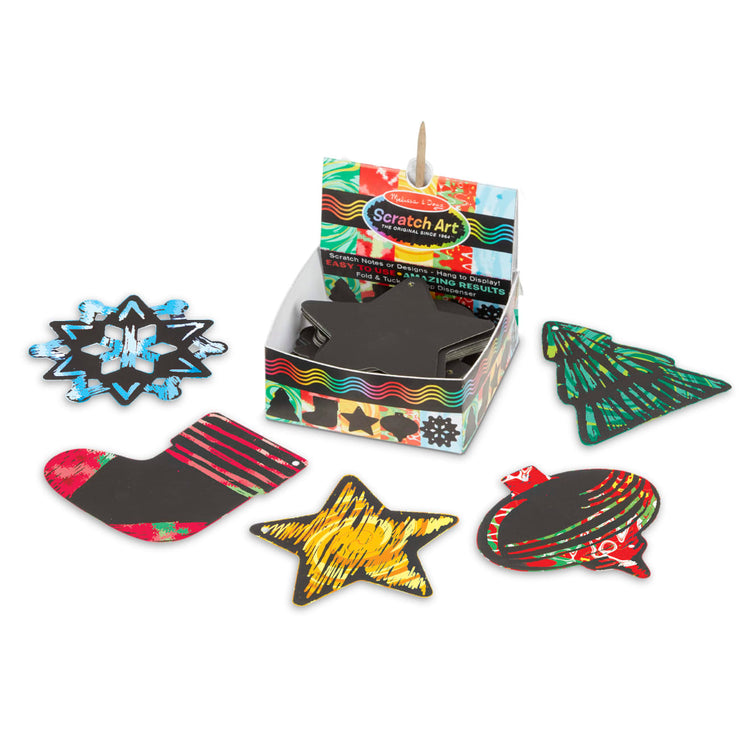 The loose pieces of the Melissa & Doug Scratch Art® Box of 125 Holiday-Themed Shaped Notes in Desktop Dispenser - Hangable Ornaments (Approx 3.5” x 3.5” Each Note)