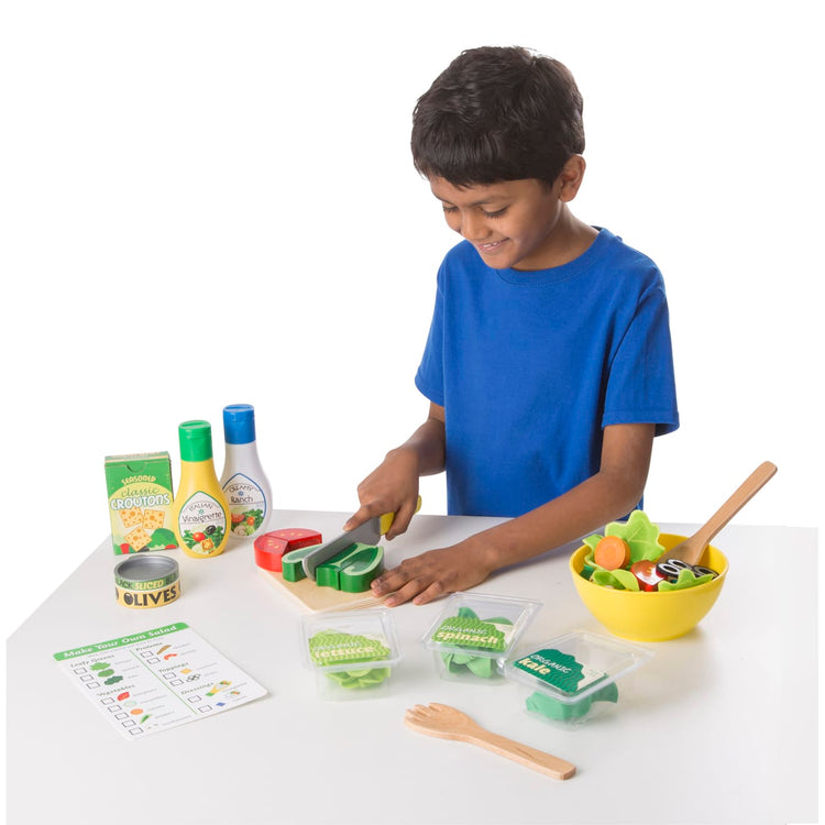 A child on white background with the Melissa & Doug Slice and Toss Salad Play Food Set – 52 Wooden and Felt Pieces